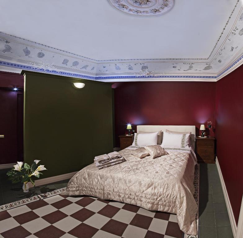 1 dormitorio con 1 cama grande y pared roja en Art Fashion House Luxury Rooms, en Catania