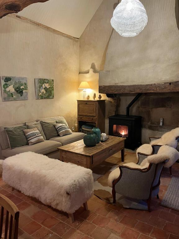 un salon avec un canapé et une cheminée dans l'établissement Domaine de La Lipomerie - LA PETITE MAISON, à Gâprée