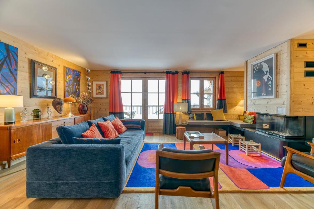 a living room with a blue couch and a table at Klochette - Charme Et Famille in Villard-Reculas