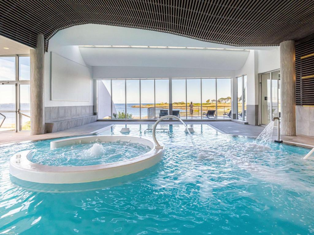 a large pool with a hot tub in a building at Sofitel Quiberon Thalassa sea & spa in Quiberon