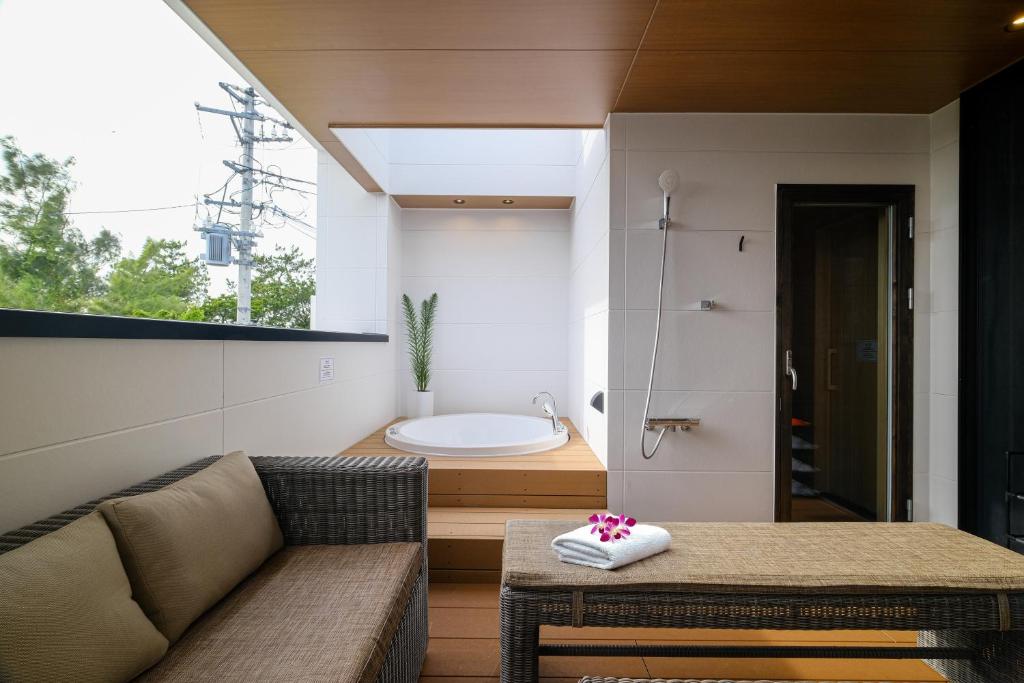 a living room with a couch and a bath tub at MIRATIO The Supreme in Onna
