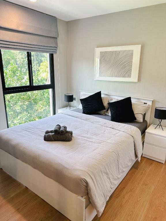 a bedroom with a large white bed and a window at Cozy Paradise By Rawai Beach in Phuket