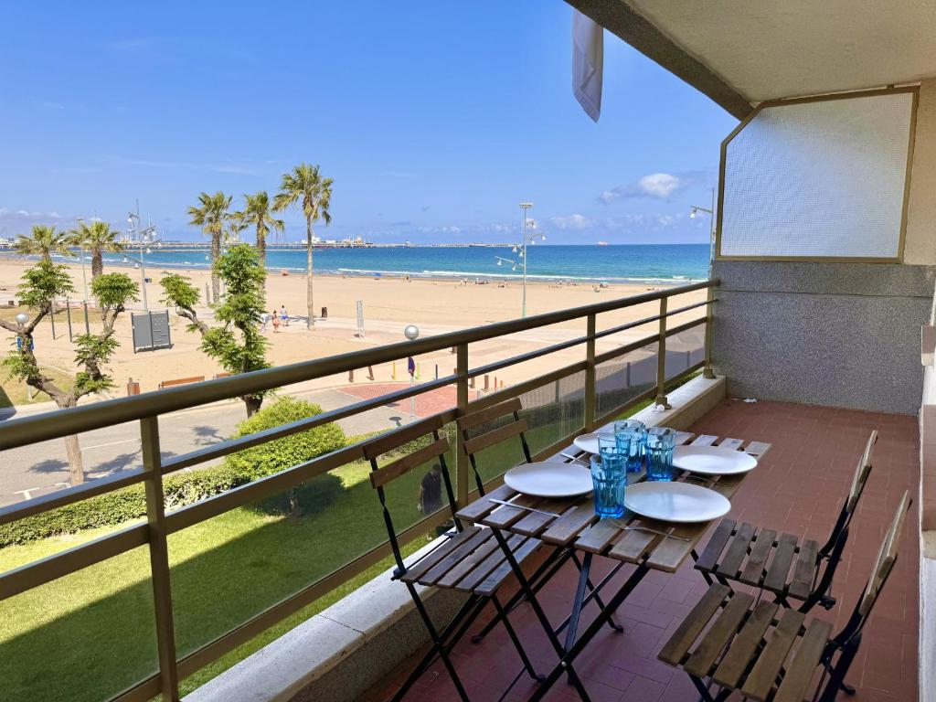 a balcony with a table and chairs and the beach at Mediterranean Way - Pineda 1 in La Pineda