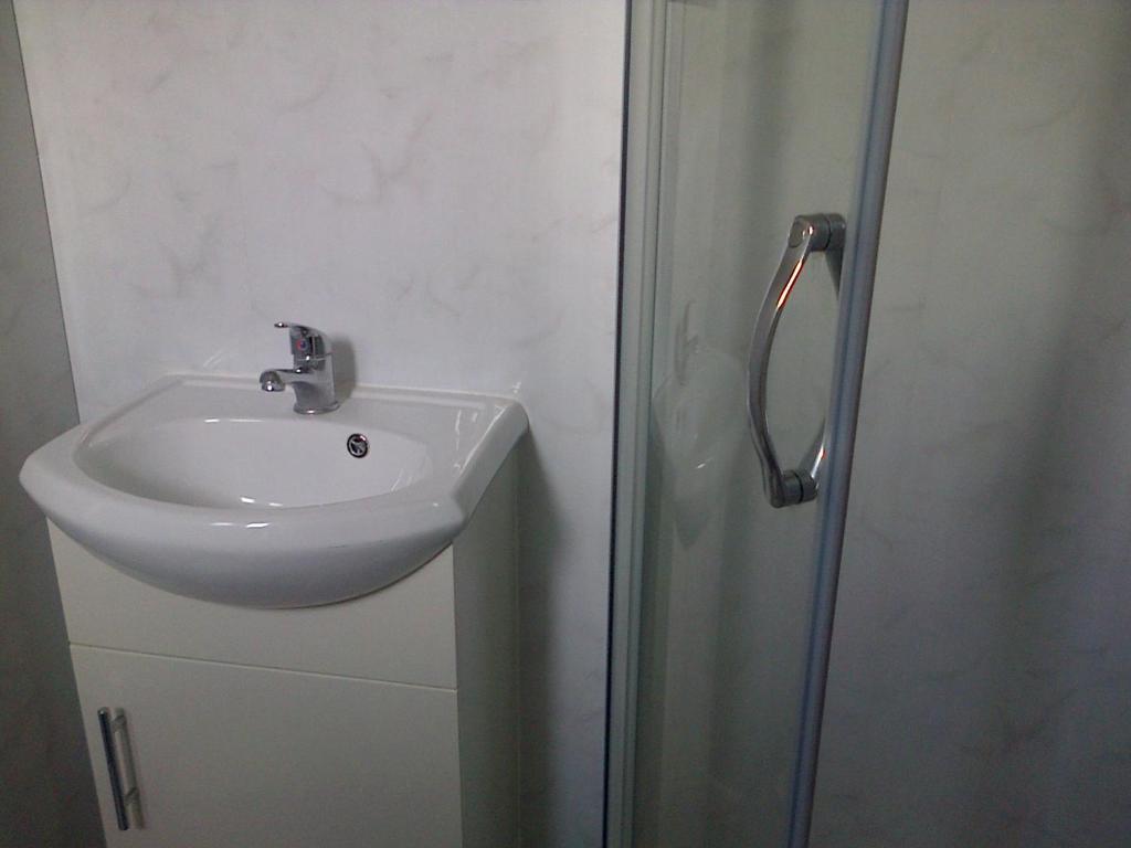 a bathroom with a sink and a shower at Lewinsdale Lodge in Weston-super-Mare