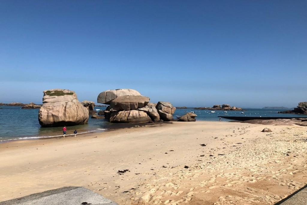 une plage avec de grands rochers dans l'eau dans l'établissement Appartement VUE SUR MER, wifi, plage du Coz-Pors à TREGASTEL - Réf 610, à Trégastel