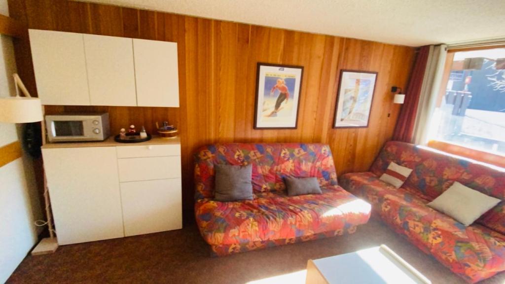 una sala de estar con un sofá y una silla en Studio Isola 2000, en Isola 2000