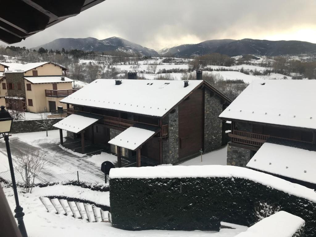 Un edificio con nieve en los tejados de un pueblo. en Cal Feliç, en Estavar