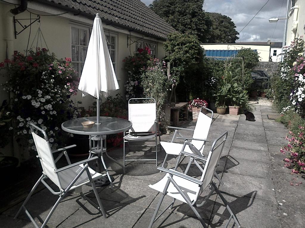 a patio with a table and chairs and an umbrella at Lewinsdale Lodge in Weston-super-Mare