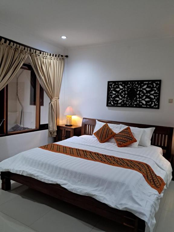 Un dormitorio con una cama grande con dos almohadas. en SURFARIS INN on poppies 2 apartment, en Legian