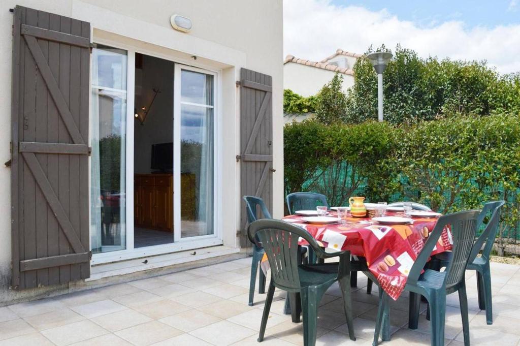 une table et des chaises sur une terrasse avec une fenêtre dans l'établissement NP110-004 Maison 4 pièces Mezzanine, Narbonne Plage, à Narbonne-Plage