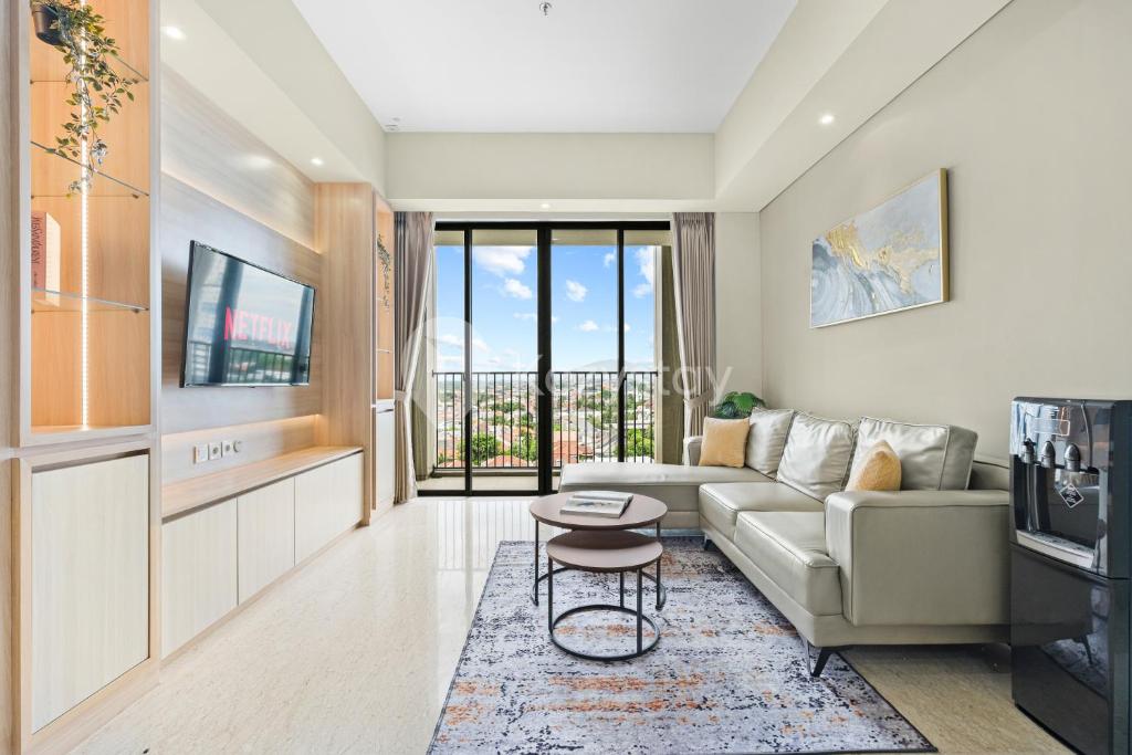 ein Wohnzimmer mit Sofa und Tisch in der Unterkunft Amica by Kozystay - Tanjung Barat in Jakarta