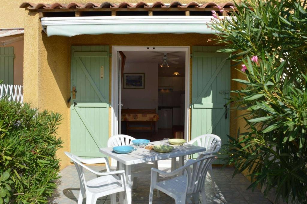 une table et des chaises assises à l'extérieur d'une maison dans l'établissement NP150-072 Pavillon 3 pièces, Narbonne Plage, à Narbonne-Plage
