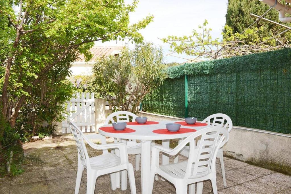 une table blanche et des chaises sur une terrasse dans l'établissement NP160-391 Pavillon Studio Mezzanine, Narbonne Plage, à Narbonne-Plage
