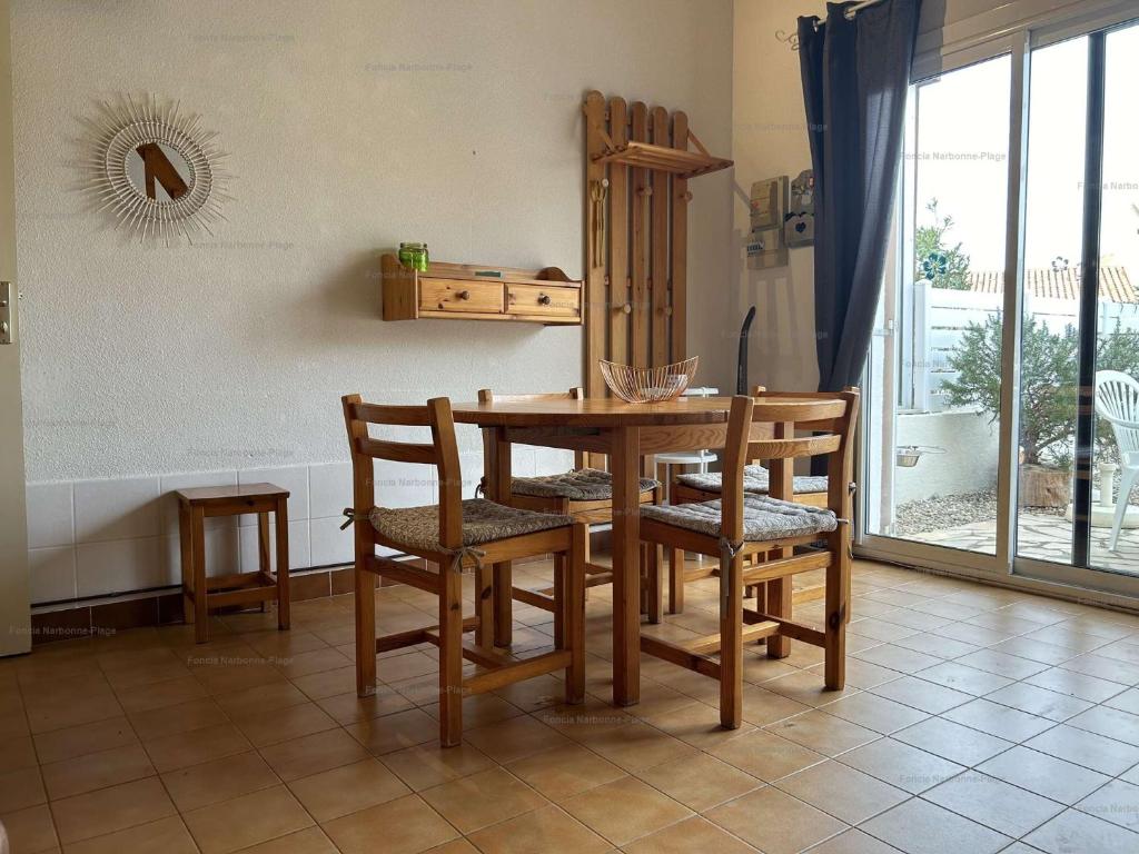 une table de salle à manger et des chaises dans une pièce dans l'établissement NP160-441 Pavillon 2 pièces mezzanine, Narbonne Plage, à Narbonne-Plage