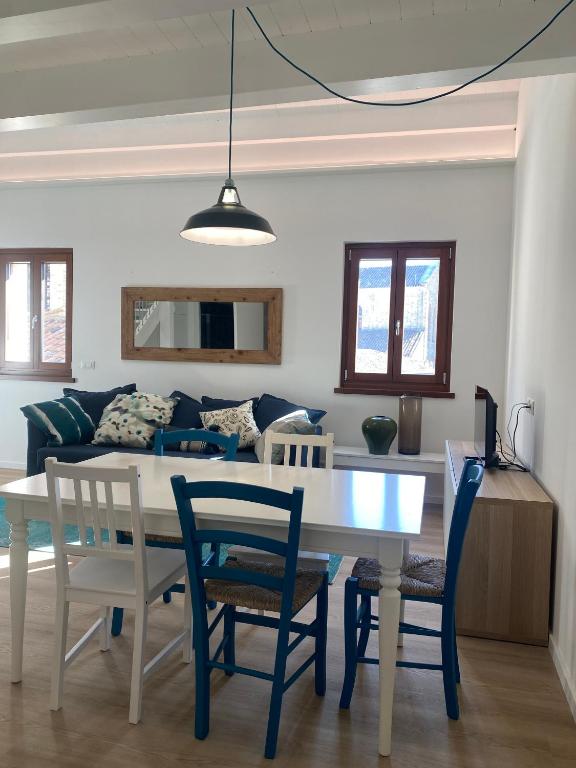 a dining room and living room with a table and chairs at Delizioso Attico Calle Lunga 2 in Grado