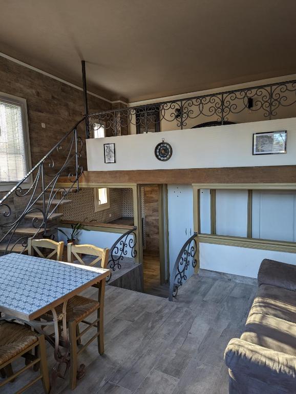 un salon avec un escalier et une table dans l'établissement Petit loft, à Elne