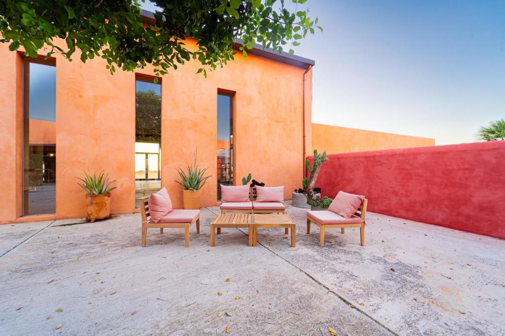 a group of chairs and a table in front of a building at Trafalgar Polo Club in El Palmar