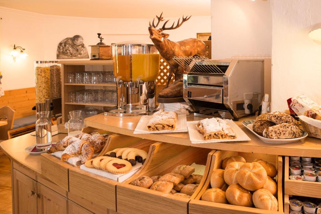 a bakery with a bunch of pastries on a shelf at Hotel Garni Snaltnerhof in Ortisei