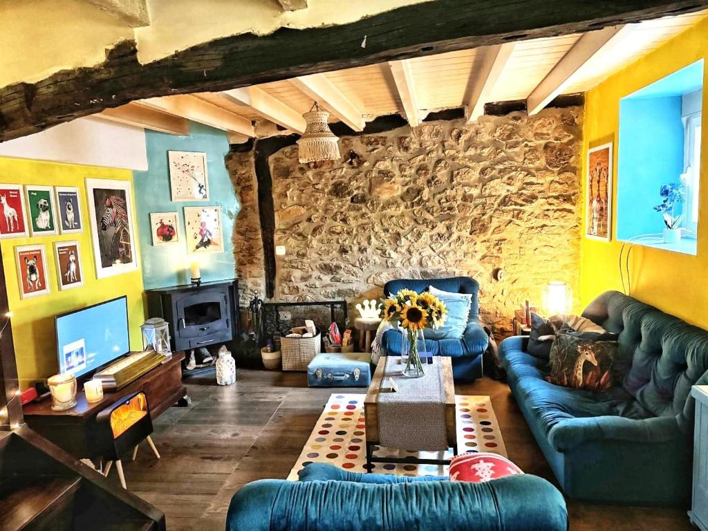 un soggiorno con divani blu e un muro in pietra di Casita Singular a Santibáñez de la Peña