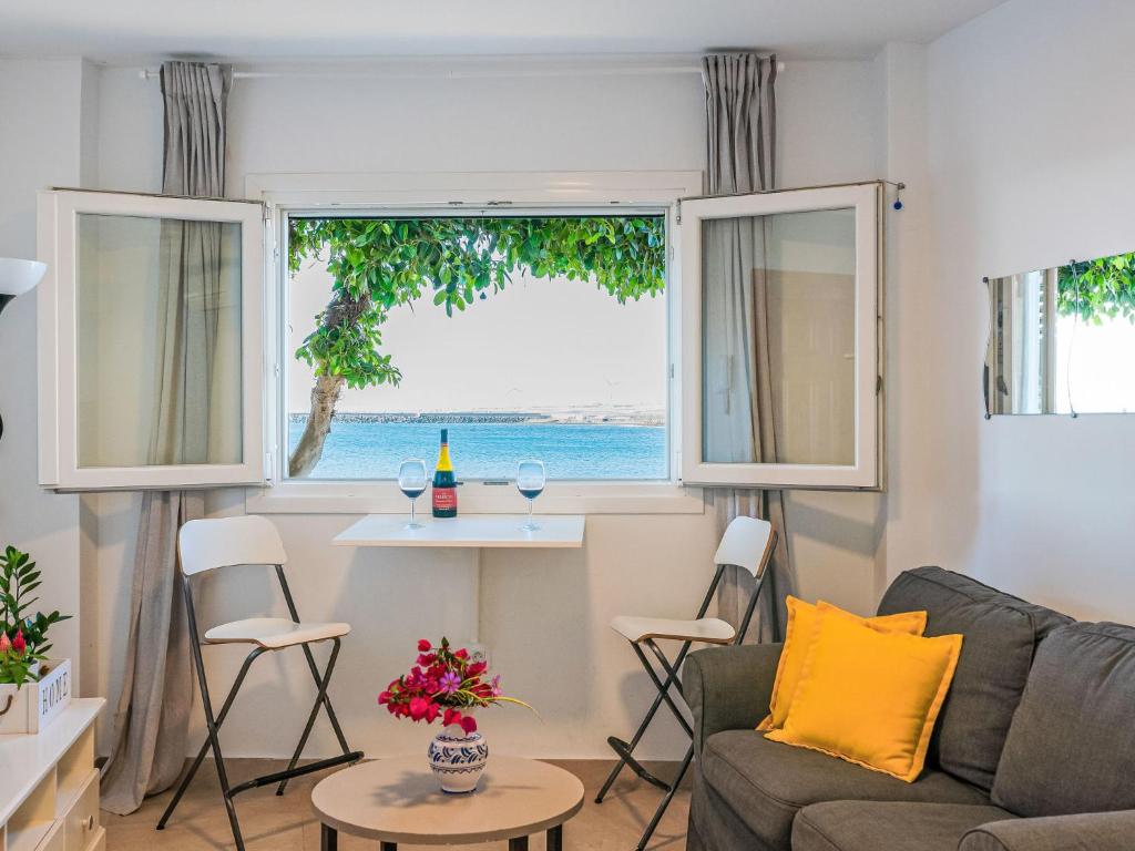 Una sala de estar con un sofá y una mesa y una ventana. en Apartment Daura by Interhome, en Arinaga