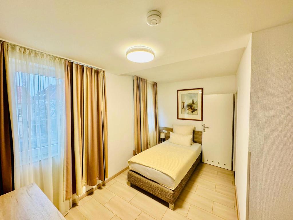 a hotel room with a bed and a window at Hotel Soad in Salach