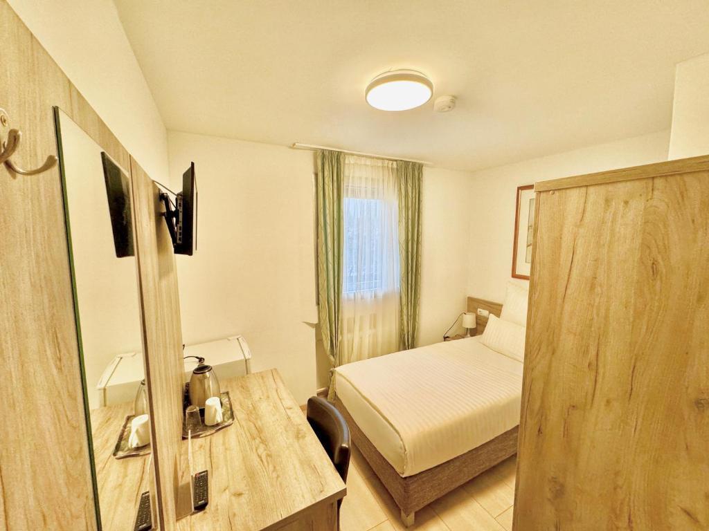 a hotel room with a bedroom with a bed and a window at Hotel Soad in Salach