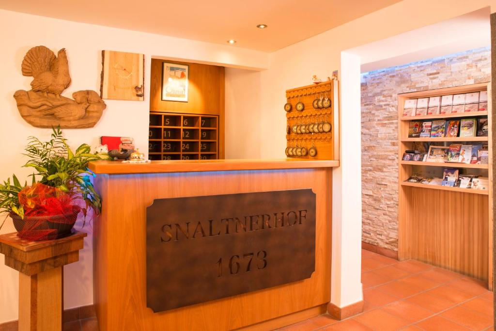 a shop with a sign on a counter in a room at Hotel Garni Snaltnerhof in Ortisei