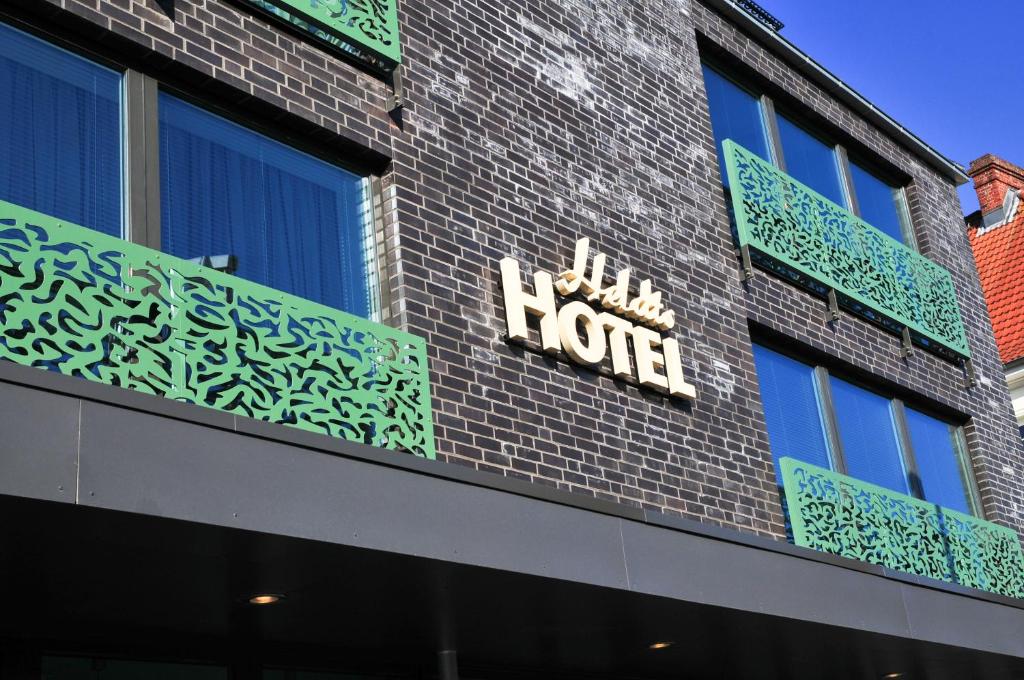 een hotelbord aan de zijkant van een bakstenen gebouw bij Heldts Aparthotel in Eckernförde