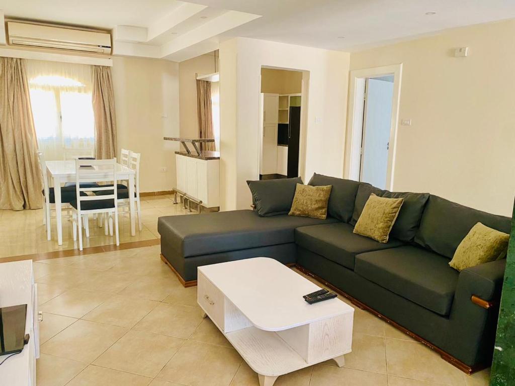 赫尔格达Hurghada-Magawish Villa 6的客厅配有绿色沙发和桌子