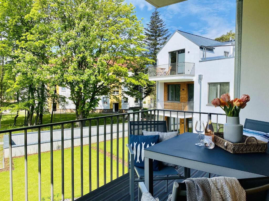 a patio with a blue table and chairs on a balcony at Ferienwohnung Ostseeliebe Parkvillen Carlota und Candela Baabe in Baabe