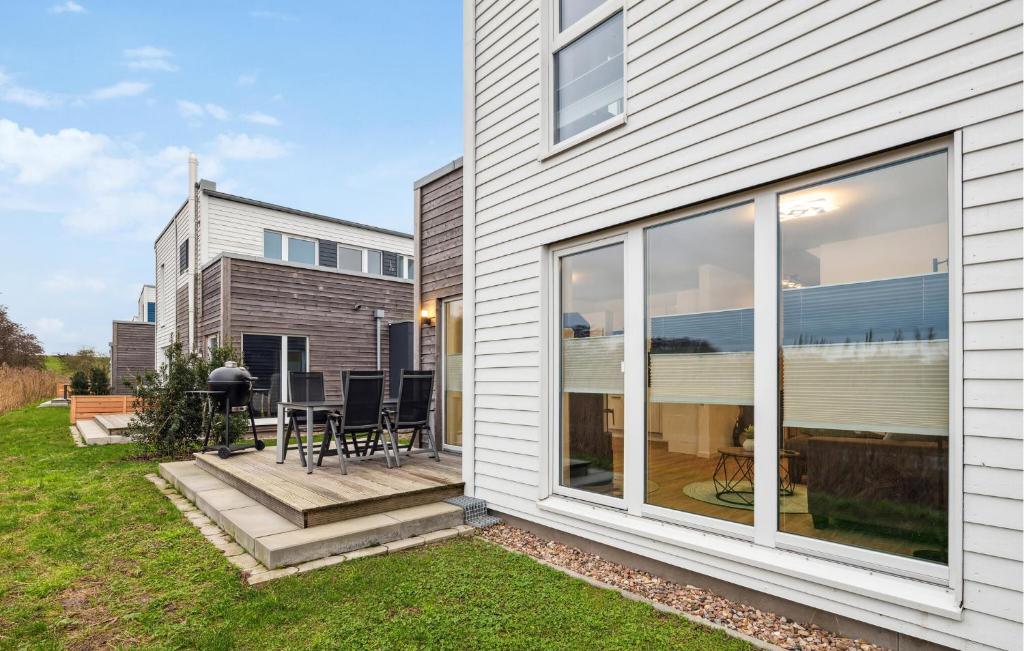 ein Haus mit Glasschiebetüren und einer Terrasse in der Unterkunft Beautiful Home In Tossens With Sauna in Tossenserdeich