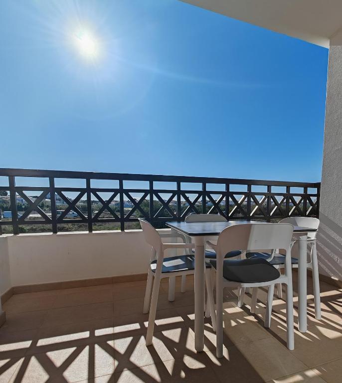 a table and chairs on a balcony with the view of the ocean at Sagres Time Apartamentos in Sagres