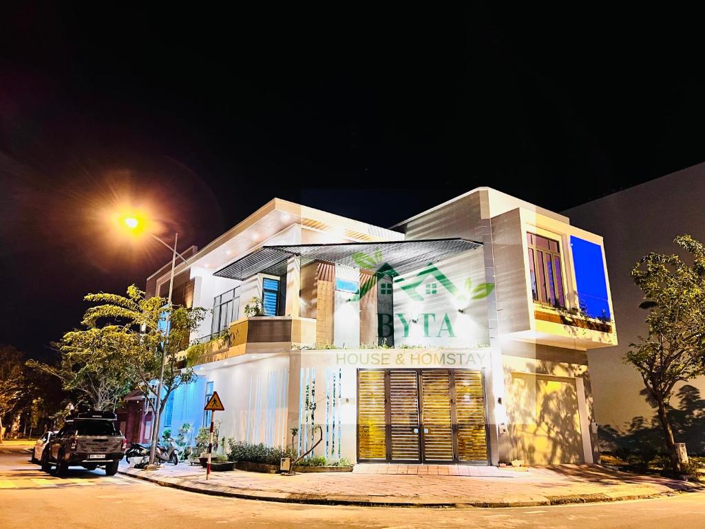 a white building with a sign on the front of it at Byta House Homestay in Kinh Dinh