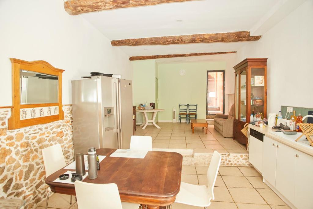 Il dispose d'une cuisine et d'un salon avec une table et des chaises en bois. dans l'établissement Maison village T5, à Fitou