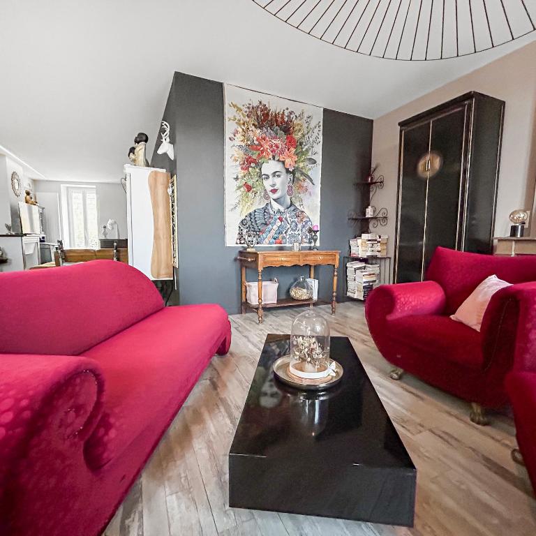 un salon avec deux canapés rouges et une table dans l'établissement Hyper centre - Spacieux avec balcon, à Roanne