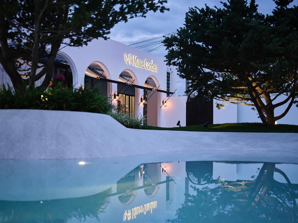 a building with a reflection in a pool of water at Muse Garden in Shanghai