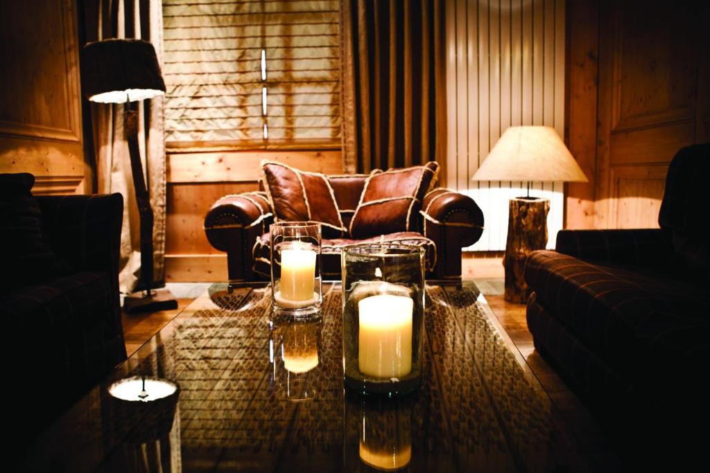 a living room with a table with candles on it at Hôtel Les Barmes De l'Ours in Val-d'Isère