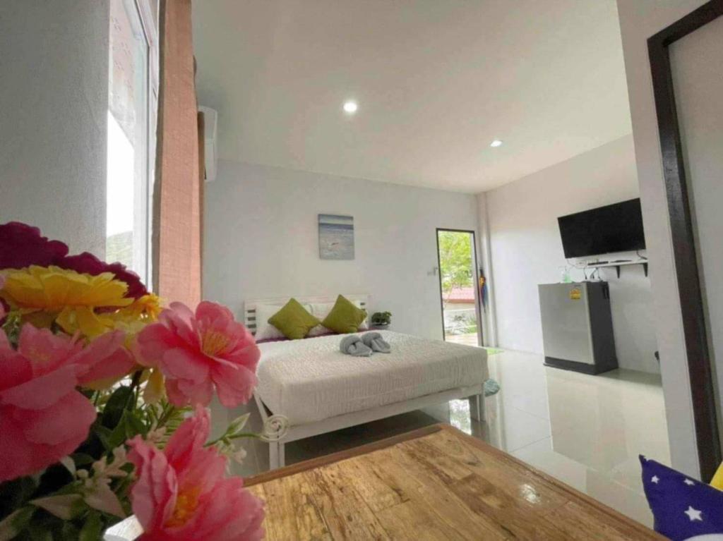 Habitación con cama y flores en el primer plano en บ้านพักแม่หมูเกาะล้าน, en Koh Larn