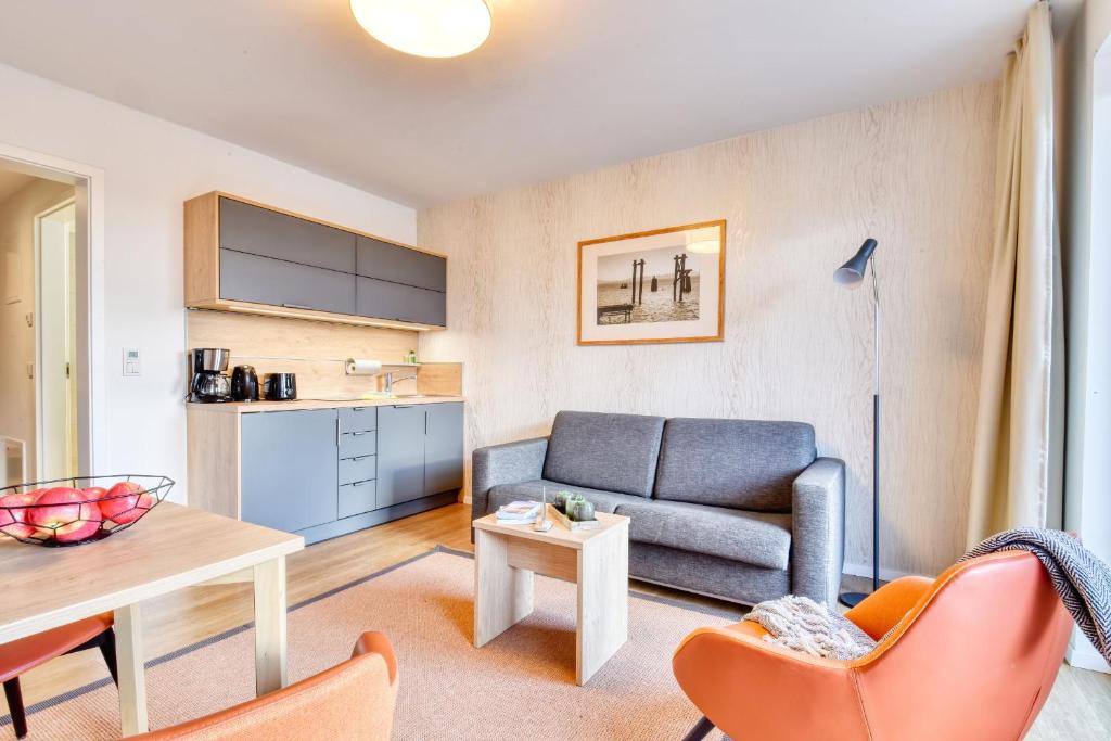 a living room with a couch and a table at Ferienwohnung Grünfink 04 im Wreecher Idyll Rügen by ruyastay in Putbus