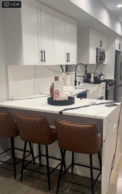 a kitchen with white cabinets and a table with a cake on it at Mixed Rustic Vibes in Chicago