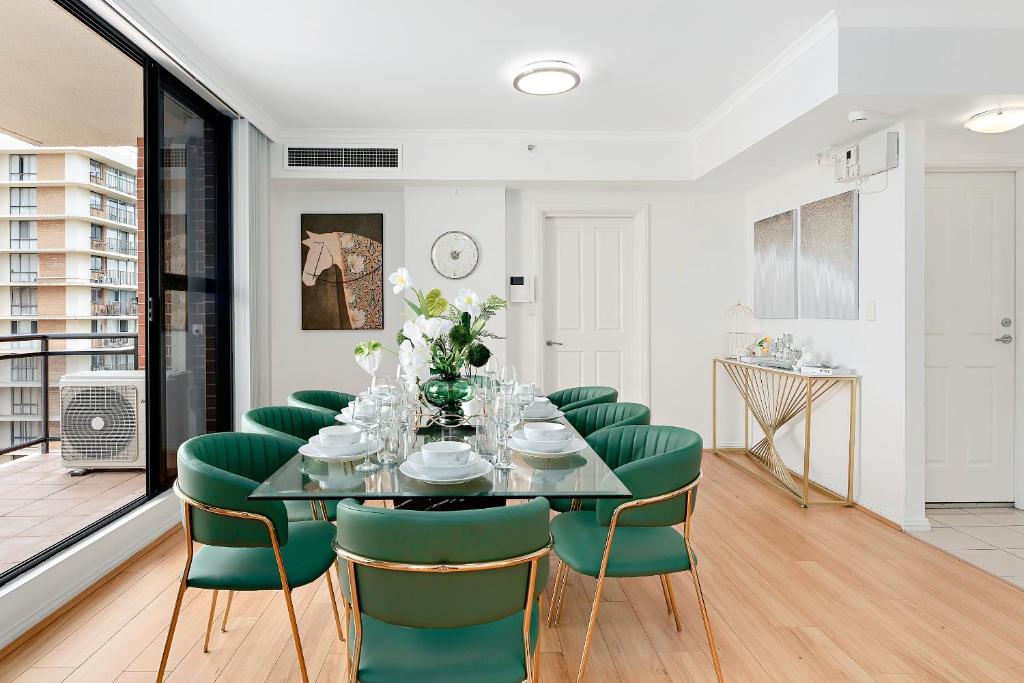 a dining room with a table and green chairs at Epic CBD city view 3BR penthouse walk to Station&shopping Centre in Sydney