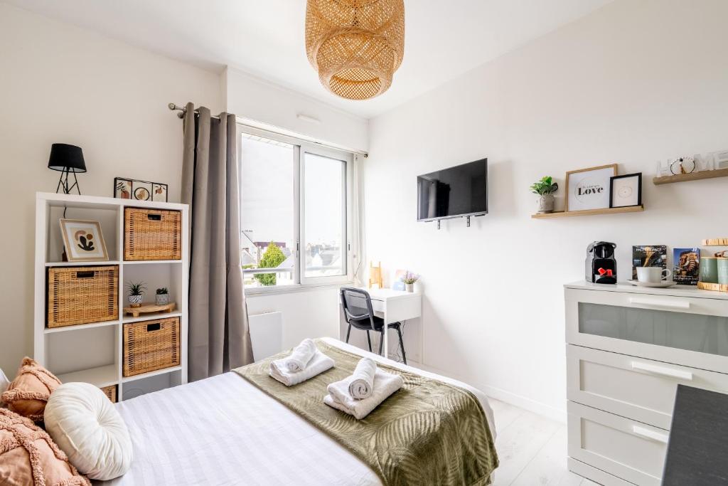 a white bedroom with a bed and a window at L'Oasis - Studio à 350m de la mer & du centre ville in Saint-Nazaire