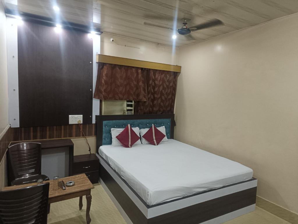 a small bedroom with a bed and a table at Shivay Guest house in Jasidih