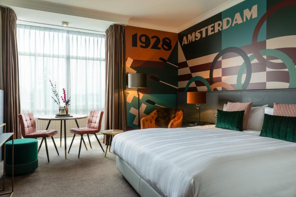a hotel room with a bed and a table at Apollo Hotel Amsterdam, a Tribute Portfolio Hotel in Amsterdam