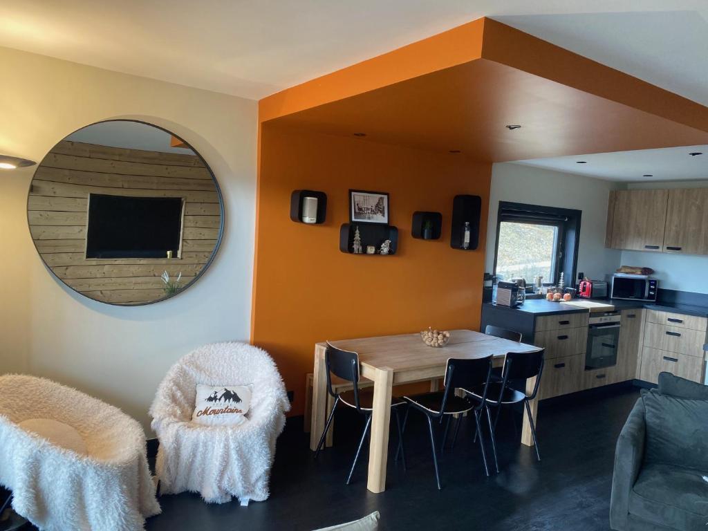 une cuisine et une salle à manger avec une table et des chaises dans l'établissement Les Glovettes pieds des pistes, à Villard-de-Lans