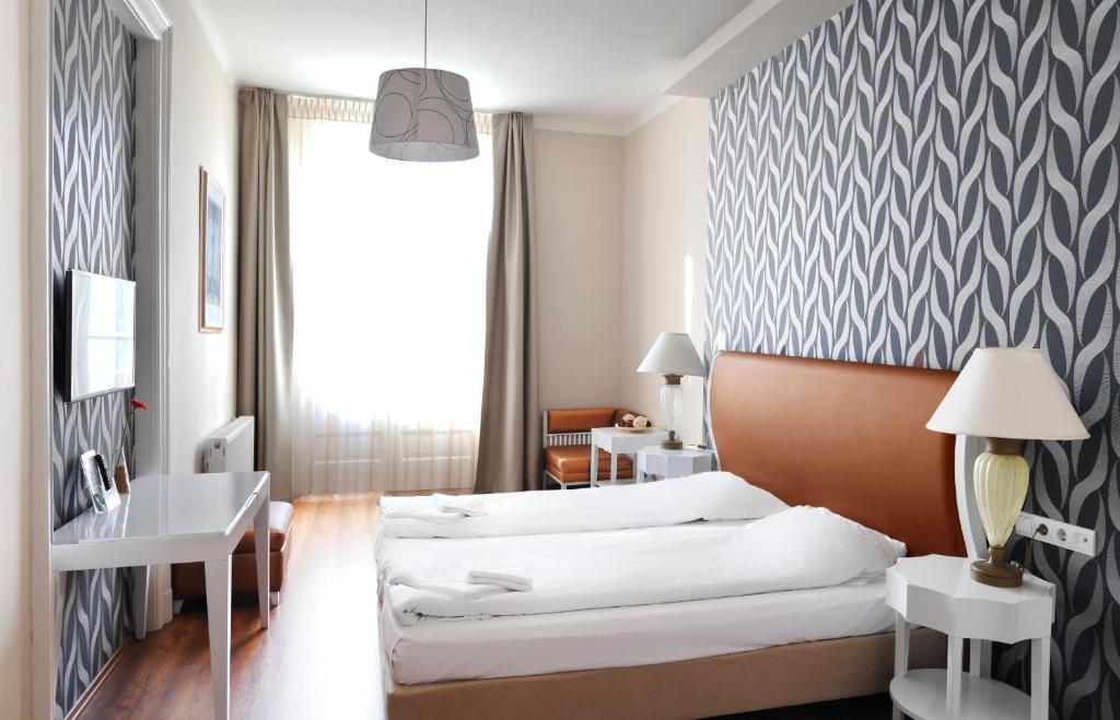 ブダペストにあるHouse Octogonのベッドとデスクが備わるホテルルームです。