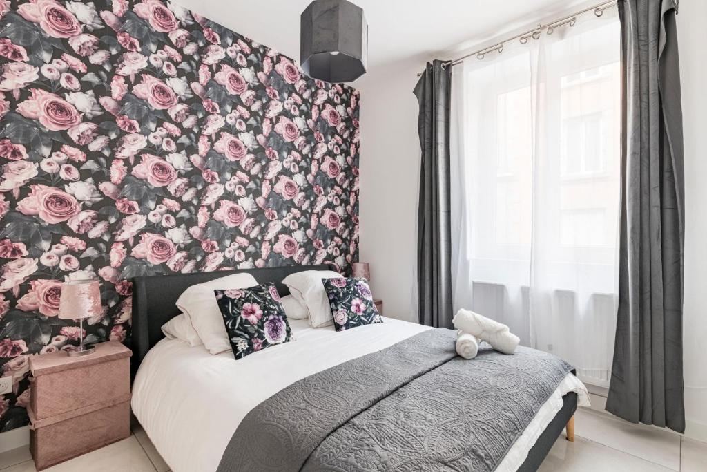 - une chambre avec un mur aux accents floraux et un lit dans l'établissement Beige hospitalité - Capucine - Floral charmant chaleureux wifi Netflix, à Saint-Étienne
