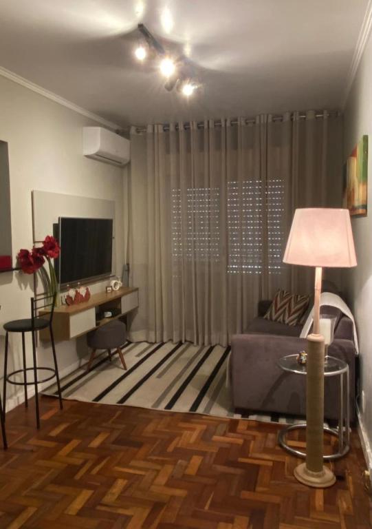 a living room with a couch and a television at Apartamento Bourbon 111 in Porto Alegre