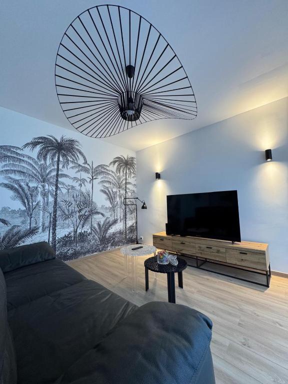 un salon avec une télévision à écran plat et un canapé dans l'établissement Maison des chênes, à Bavilliers