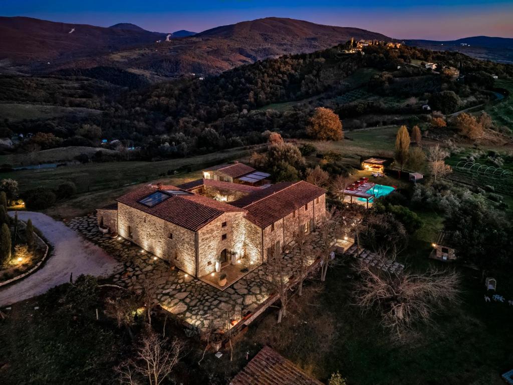 an aerial view of a house in the hills at La Pieve di San Giovanni Luxury Retreat & Spa in Lustignano
